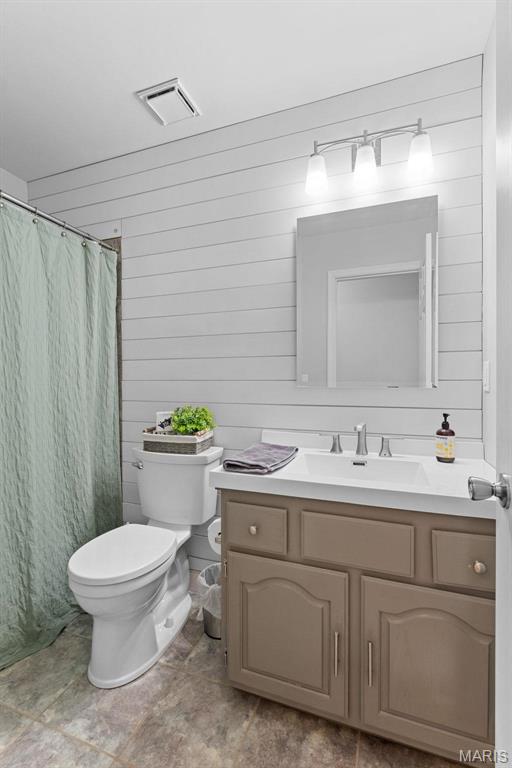 19120 Hawk Mountain Rd, Wildwood, MO 63038 - full bath featuring vanity, wooden walls, toilet, and a shower with shower curtain