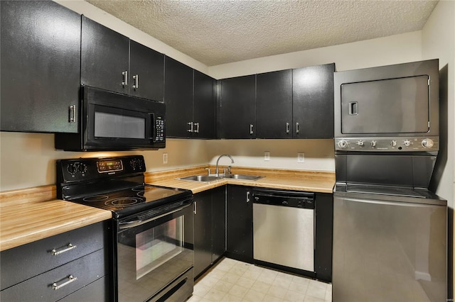 1626 High School Dr, Saint Louis, MO 63144 - kitchen with black appliances, a sink, stacked washing machine and dryer, dark cabinetry, and a textured ceiling