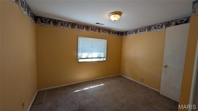 carpeted spare room featuring baseboards