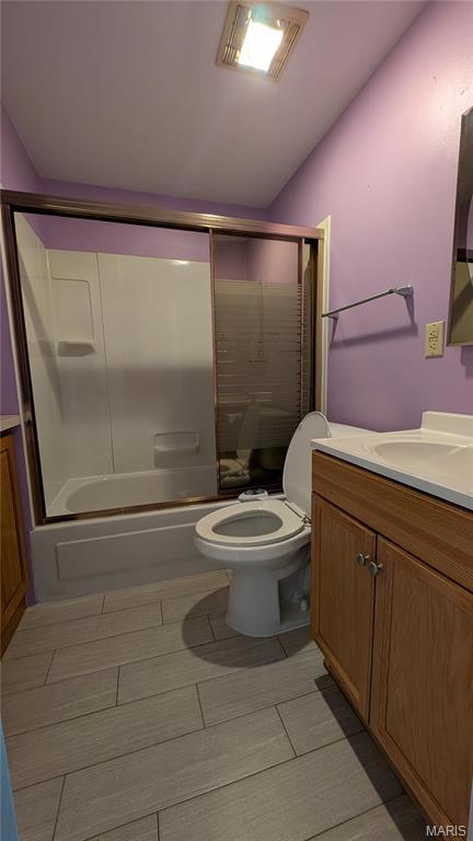 full bathroom featuring bath / shower combo with glass door, toilet, and vanity