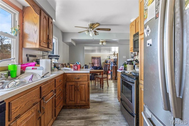 4279 Ee Hwy, Farmington, MO 63640 - kitchen with stainless steel appliances, wood finished floors, light countertops, a ceiling fan, and a peninsula