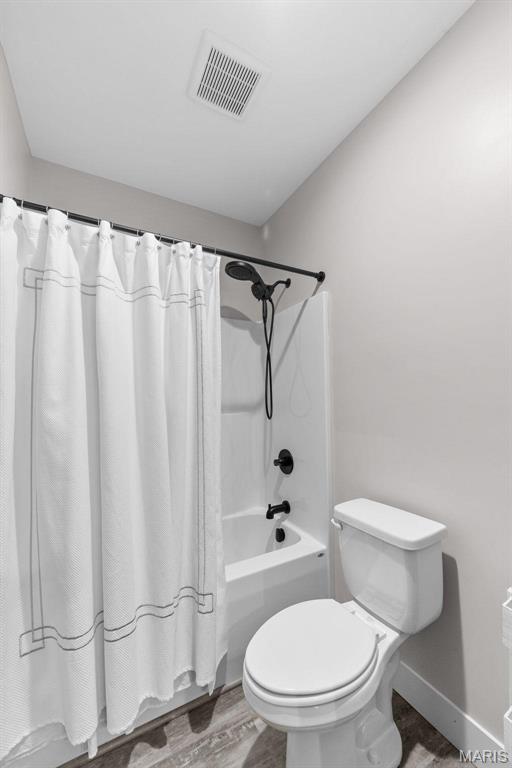3545 Cappeln Osage Rd, Marthasville, MO 63357 - bathroom featuring wood finished floors, baseboards, toilet, and shower / bath combination with curtain