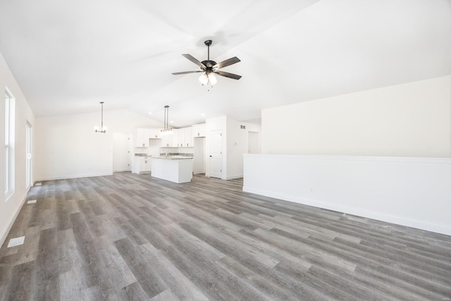 7349 Providence, Edwardsville, IL 62025 - unfurnished living room with vaulted ceiling, ceiling fan, baseboards, light wood-type flooring, and a chandelier