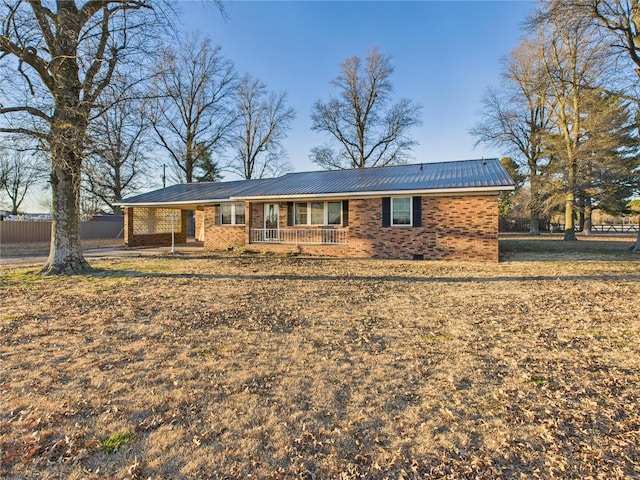 view of front of property featuring brick siding, covered porch, metal roof, crawl space, and fence
