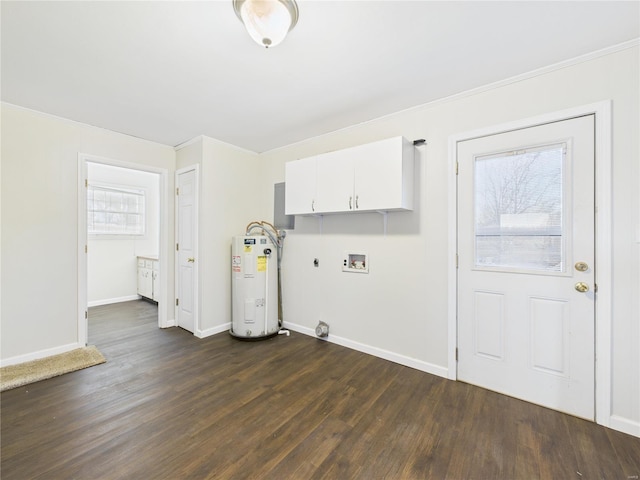 washroom featuring water heater, dark wood-style floors, cabinet space, hookup for a washing machine, and baseboards