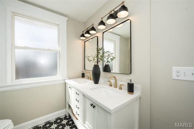 7642 Westmoreland Ave, Saint Louis, MO 63105 - bathroom featuring tile patterned floors, double vanity, baseboards, and toilet
