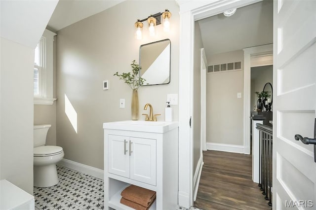 7642 Westmoreland Ave, Saint Louis, MO 63105 - bathroom featuring baseboards, toilet, and vanity