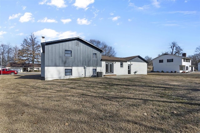 470 Saint Paul Dr, New Madrid, MO 63869 - rear view of property featuring a chimney, board and batten siding, a lawn, and brick siding