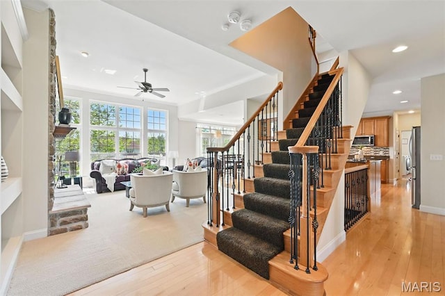 staircase featuring ceiling fan, wood-type flooring, recessed lighting, and baseboards