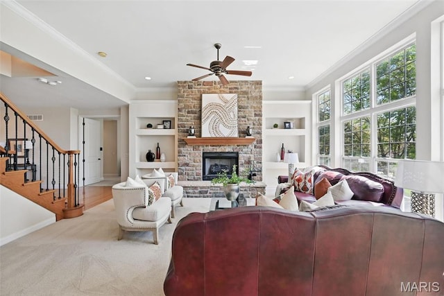 living room featuring ornamental molding, built in shelves, a ceiling fan, baseboards, and a fireplace