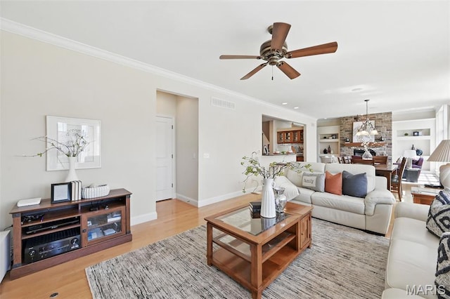 living area with ceiling fan, light wood finished floors, crown molding, baseboards, and a chandelier