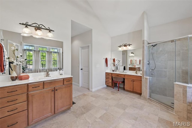 full bath with a stall shower, two vanities, and vaulted ceiling