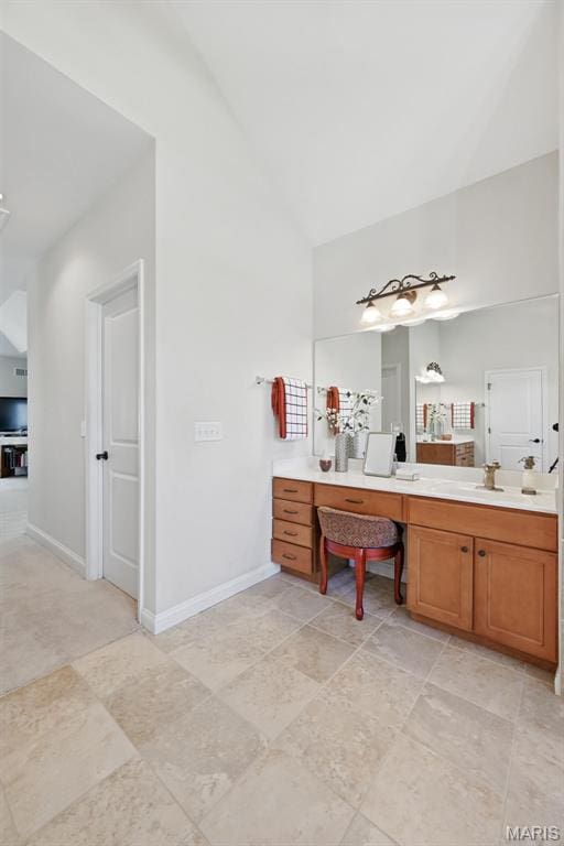 full bathroom with high vaulted ceiling, vanity, and baseboards