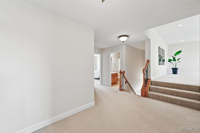hallway with light carpet, baseboards, an upstairs landing, and recessed lighting