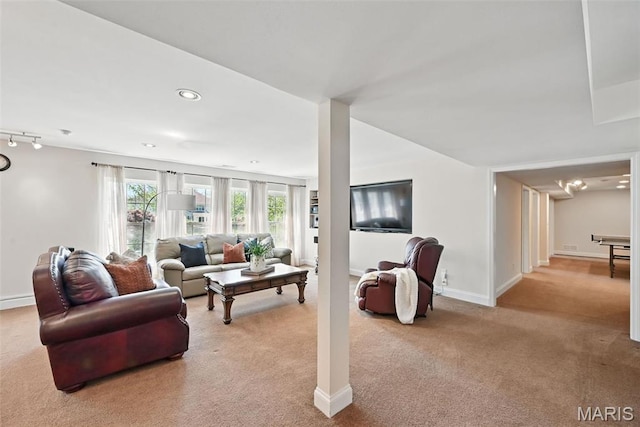 living area with light colored carpet and baseboards