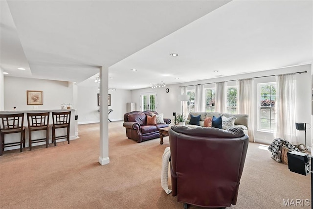 living area featuring light carpet, recessed lighting, and baseboards