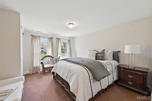 bedroom featuring dark colored carpet and baseboards