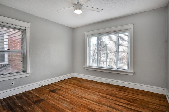 empty room featuring baseboards, wood finished floors, ceiling fan, and a textured ceiling