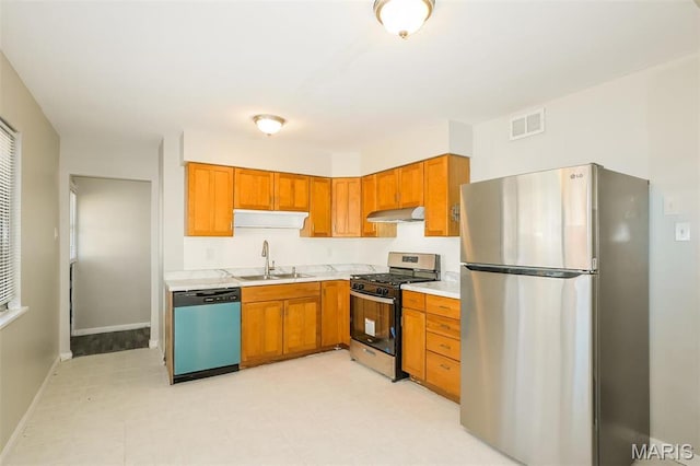 1235 Flicker Dr, Florissant, MO 63031 - kitchen featuring appliances with stainless steel finishes, under cabinet range hood, light countertops, and brown cabinets