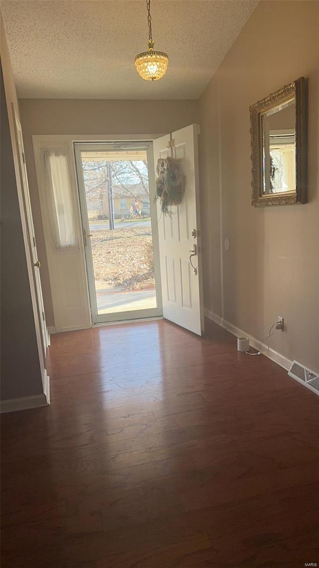 810 E Cedar St, Bertrand, MO 63823 - foyer entrance featuring dark wood-type flooring, baseboards, and a textured ceiling
