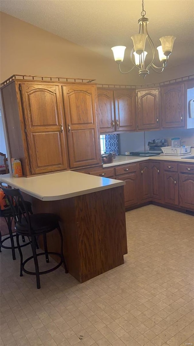810 E Cedar St, Bertrand, MO 63823 - kitchen with light countertops, hanging light fixtures, a chandelier, a kitchen breakfast bar, and a sink