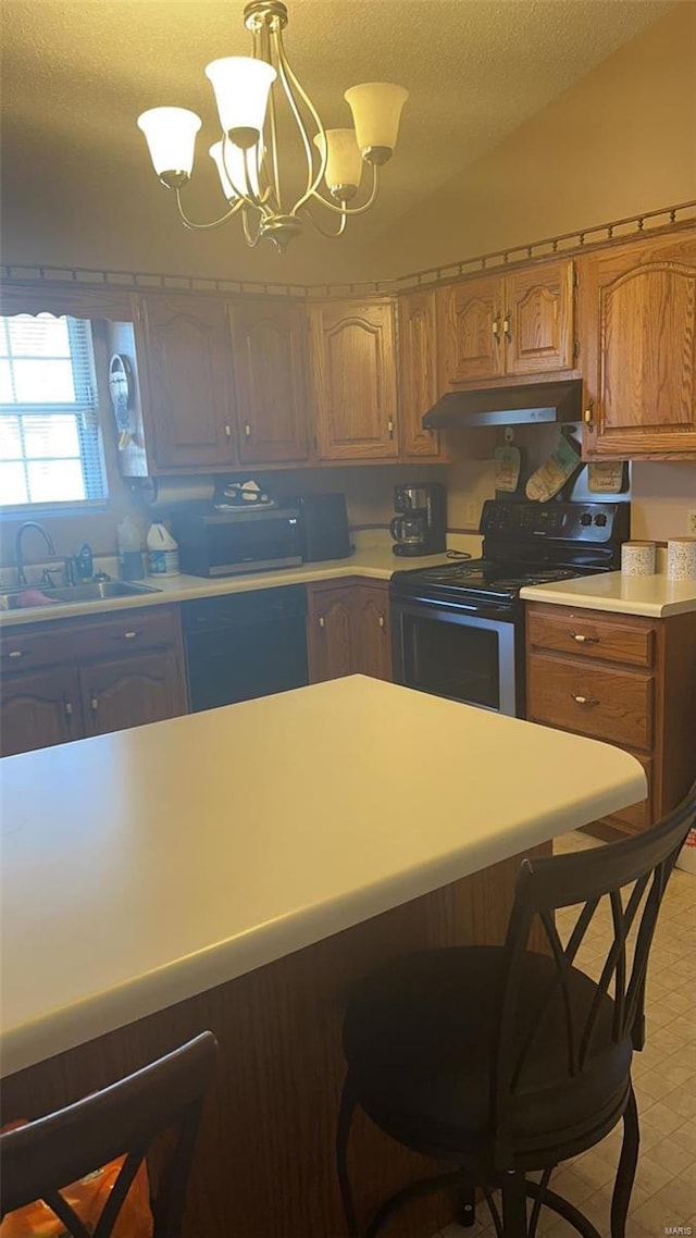 810 E Cedar St, Bertrand, MO 63823 - kitchen featuring stainless steel appliances, under cabinet range hood, a sink, light countertops, and a breakfast bar
