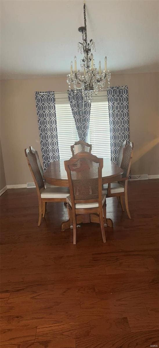 810 E Cedar St, Bertrand, MO 63823 - dining space featuring a chandelier, baseboards, and wood finished floors