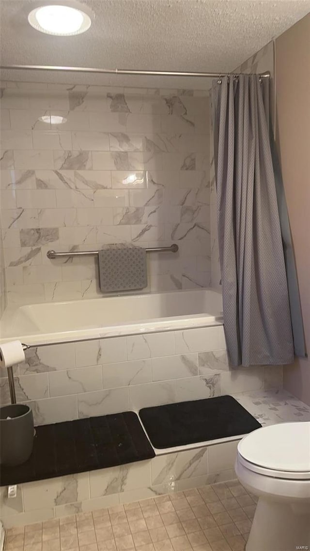 810 E Cedar St, Bertrand, MO 63823 - bathroom featuring a textured ceiling, tiled shower / bath, toilet, and marble look tile flooring