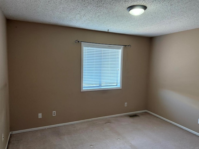 unfurnished room featuring carpet flooring, a textured ceiling, and baseboards