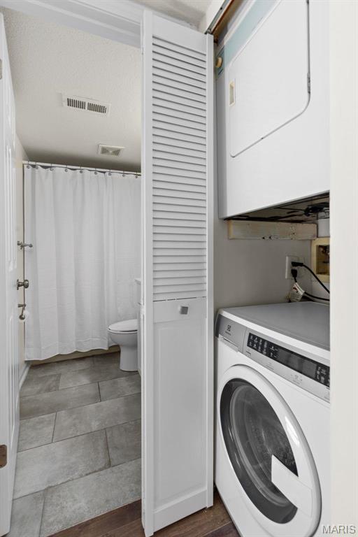 1773 High School Dr, Brentwood, MO 63144 - clothes washing area with estacked washer and dryer