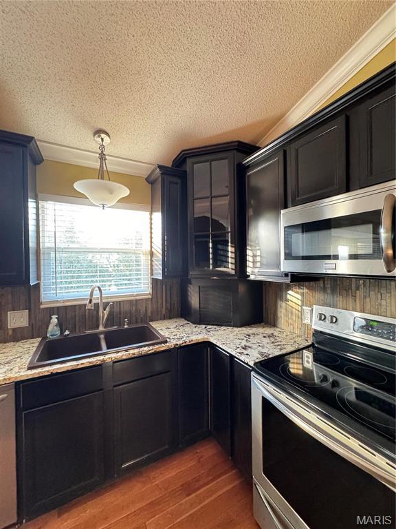 5284 Summer Cir, Imperial, MO 63052 - kitchen with stainless steel appliances, a sink, a textured ceiling, wood finished floors, and crown molding