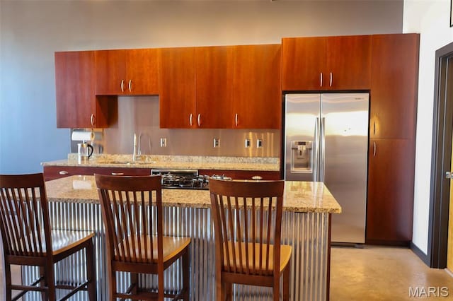 1015 Washington Ave Unit 609, Saint Louis, MO 63101 - kitchen with stainless steel fridge, a sink, light stone countertops, and brown cabinets