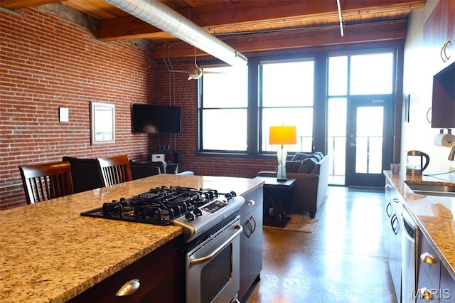 1015 Washington Ave Unit 609, Saint Louis, MO 63101 - kitchen featuring appliances with stainless steel finishes, brick wall, healthy amount of natural light, and light stone counters