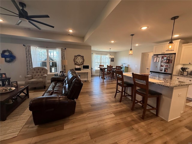 living area with ceiling fan, wood finished floors, and recessed lighting