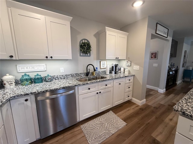 kitchen with stainless steel dishwasher, a sink, dark wood-type flooring, white cabinets, and recessed lighting