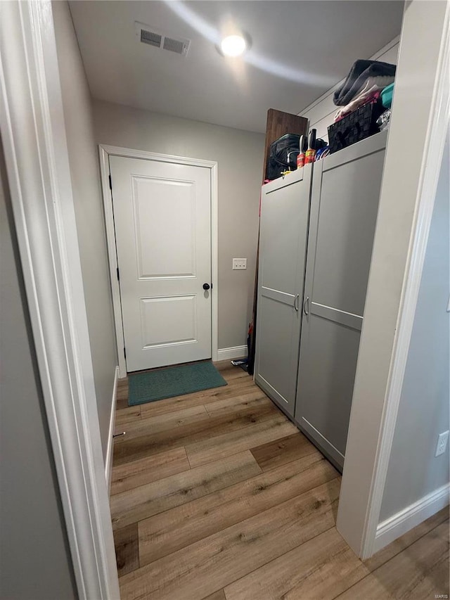 doorway to outside with light wood finished floors and baseboards