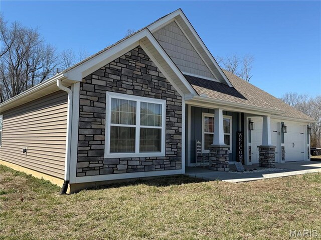 379 Lakeview Cpe, Girardeau, MO 63701 - view of side of property with stone siding, an attached garage, covered porch, and a lawn