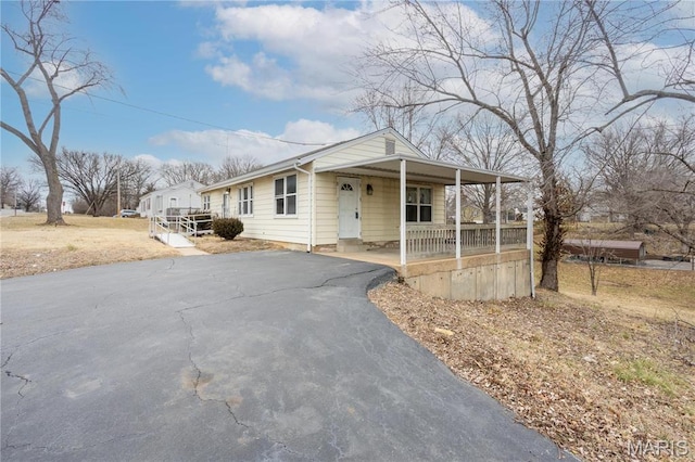 4 New Sugar Creek Rd, Fenton, MO 63026 - view of front of house with a porch, asphalt driveway, and an attached carport