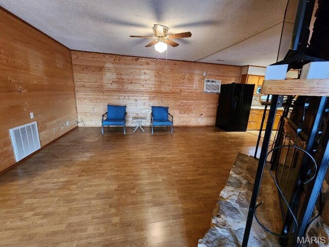 1504 Main St, Van Buren, MO 63965 - unfurnished room featuring ceiling fan, a textured ceiling, wood finished floors, and wooden walls