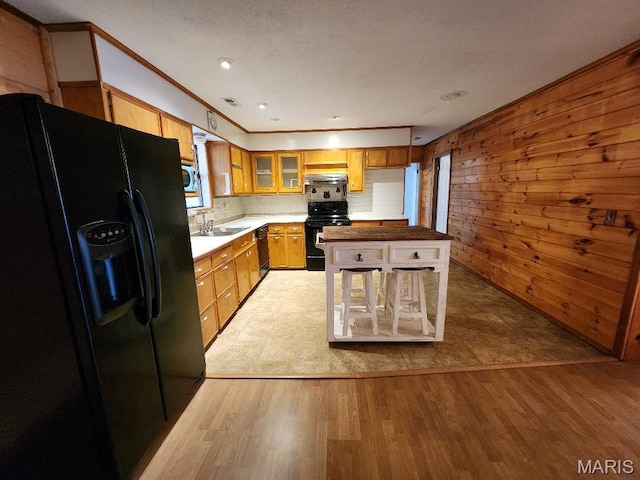 1504 Main St, Van Buren, MO 63965 - kitchen with black appliances, light wood finished floors, a sink, glass insert cabinets, and ornamental molding