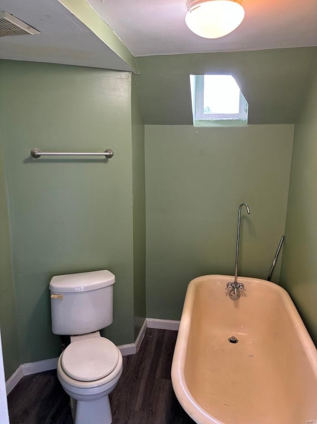 4172 Delmar Blvd, Saint Louis, MO 63108 - full bathroom featuring wood finished floors, a freestanding tub, toilet, and baseboards
