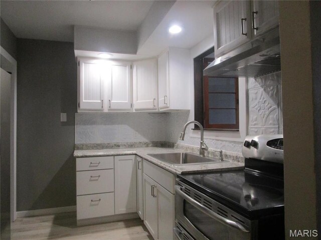 7 Pineview Ln, Collinsville, IL 62234 - kitchen featuring range with two ovens, a sink, under cabinet range hood, light countertops, and white cabinets