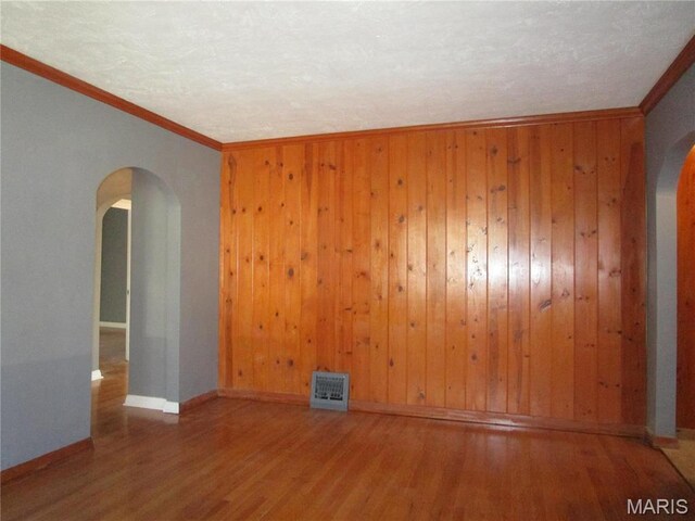 7 Pineview Ln, Collinsville, IL 62234 - spare room featuring arched walkways, wood finished floors, crown molding, baseboards, and wood walls