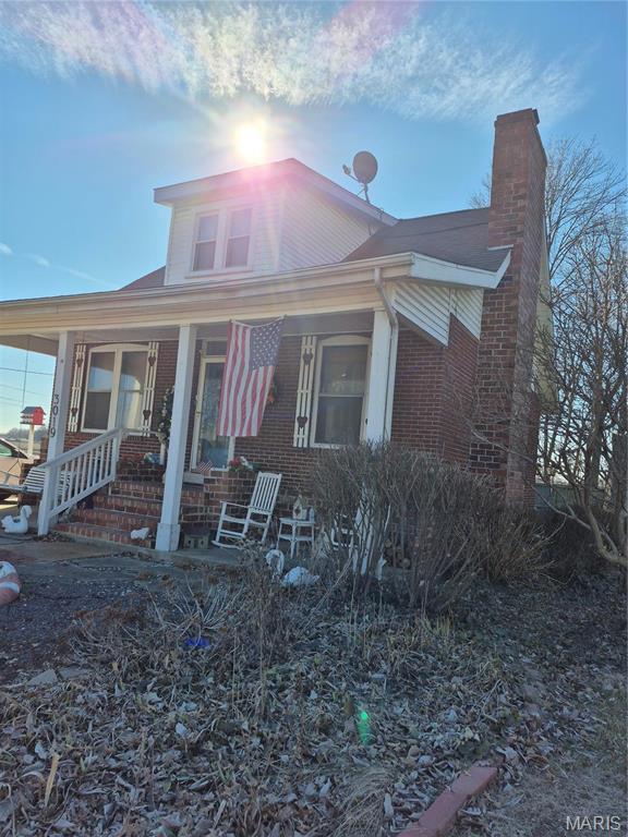 3019 Mockingbird Ln, Granite City, IL 62040 - bungalow-style house with brick siding, covered porch, and a chimney