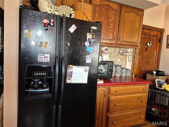 3019 Mockingbird Ln, Granite City, IL 62040 - kitchen with black refrigerator with ice dispenser, tasteful backsplash, and brown cabinets