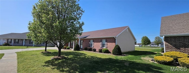 view of front of house with brick siding and a front yard
