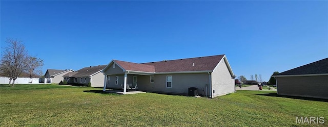 back of property featuring a lawn, a patio, and central AC
