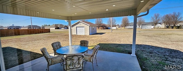 view of patio / terrace featuring a storage shed, an outbuilding, a residential view, and outdoor dining area