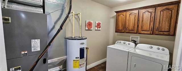 laundry room with water heater, washing machine and dryer, heating unit, cabinet space, and baseboards