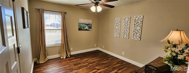 spare room featuring dark wood-style floors, baseboards, and a ceiling fan